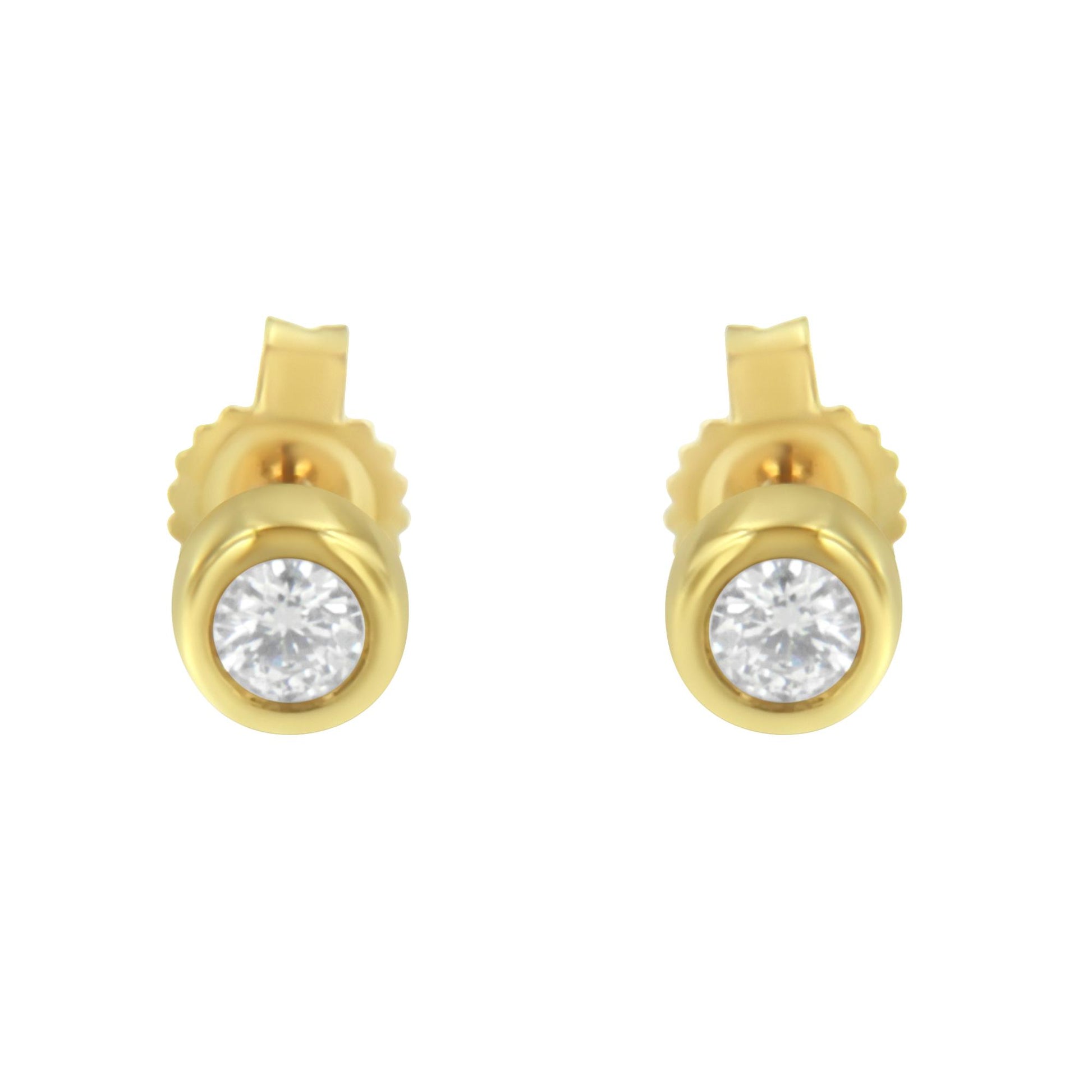 Front view of a pair of yellow metal stud earrings with round white gemstones in bezel settings.