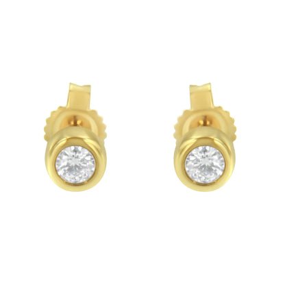 Front view of a pair of yellow metal stud earrings with round white gemstones in bezel settings.