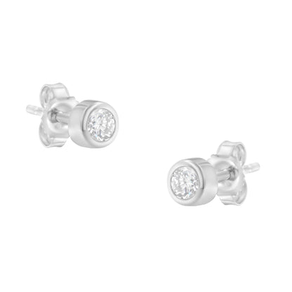 Pair of white metal stud earrings with round bezel-set white gemstones, shown at an angled close-up view.
