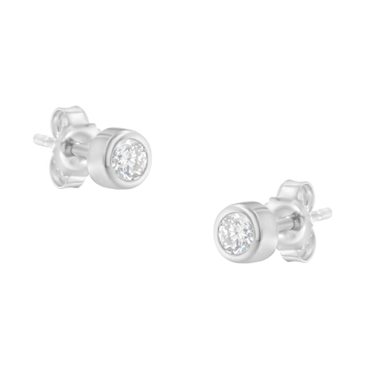 Pair of white metal stud earrings with round bezel-set white gemstones, shown at an angled close-up view.