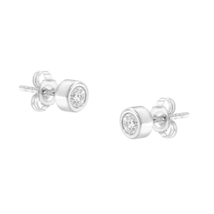 Pair of white metal stud earrings with round white gemstones in bezel settings, shown at a slight angle.