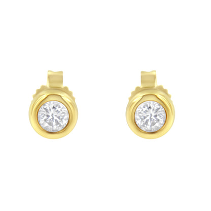 Front view of yellow metal stud earrings with round white gemstones in bezel settings.