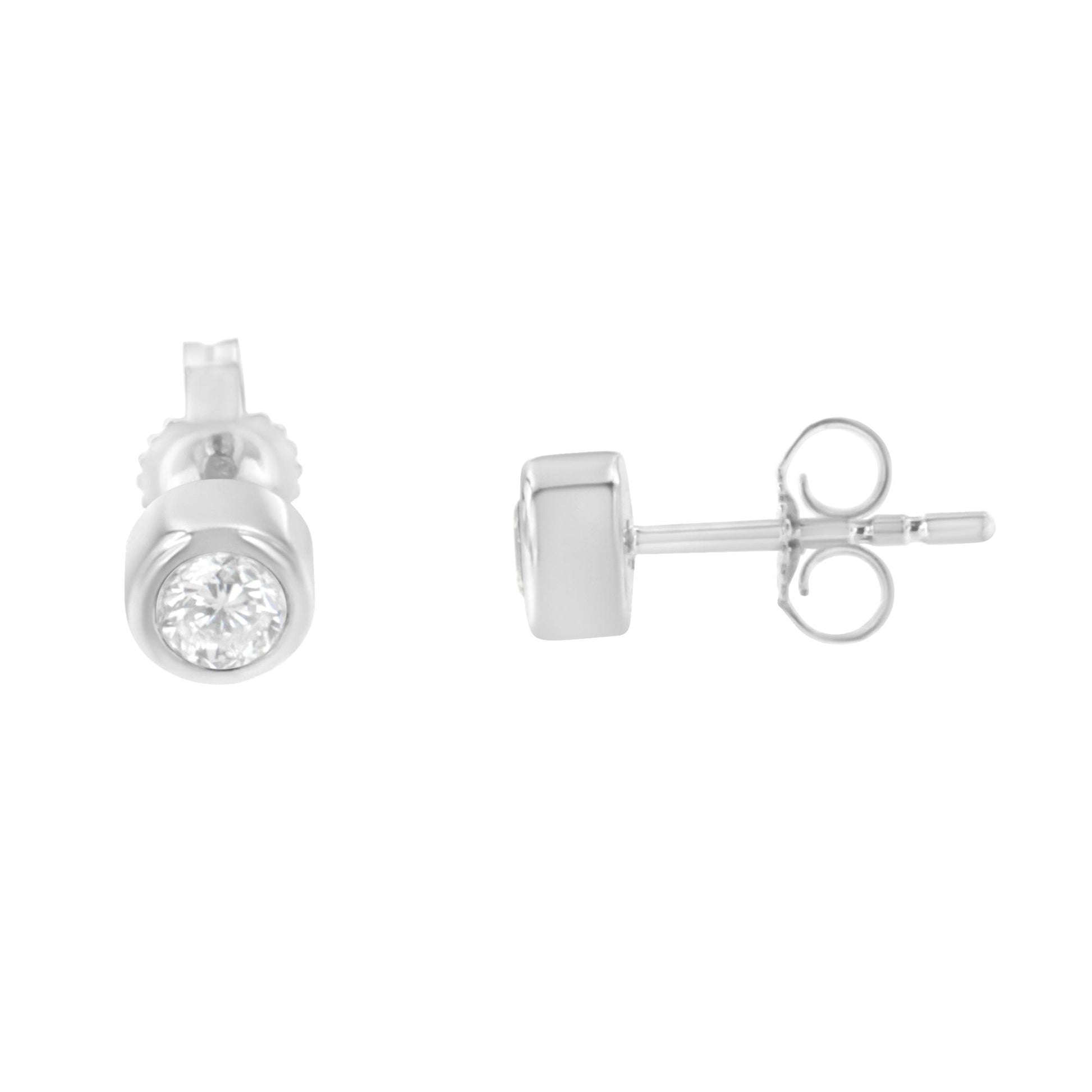 Front and side view of white metal stud earrings with round white gemstones in bezel setting.