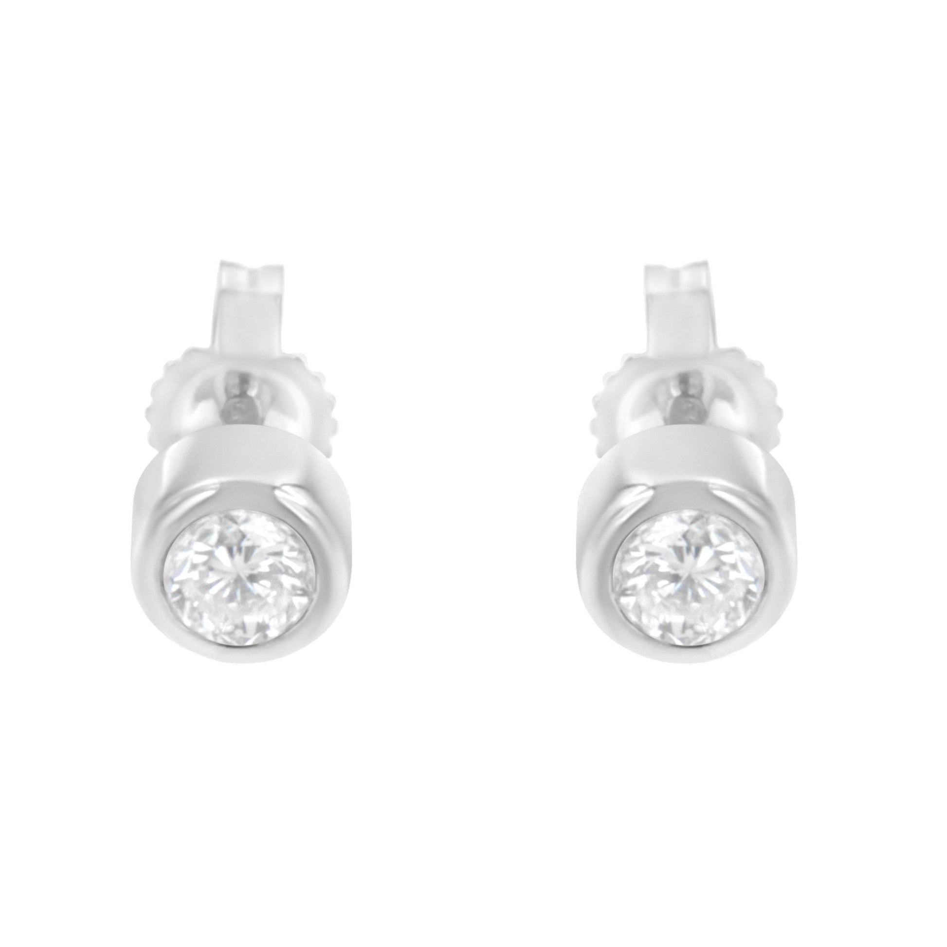 Front view of white metal stud earrings with round white gemstones in bezel settings.