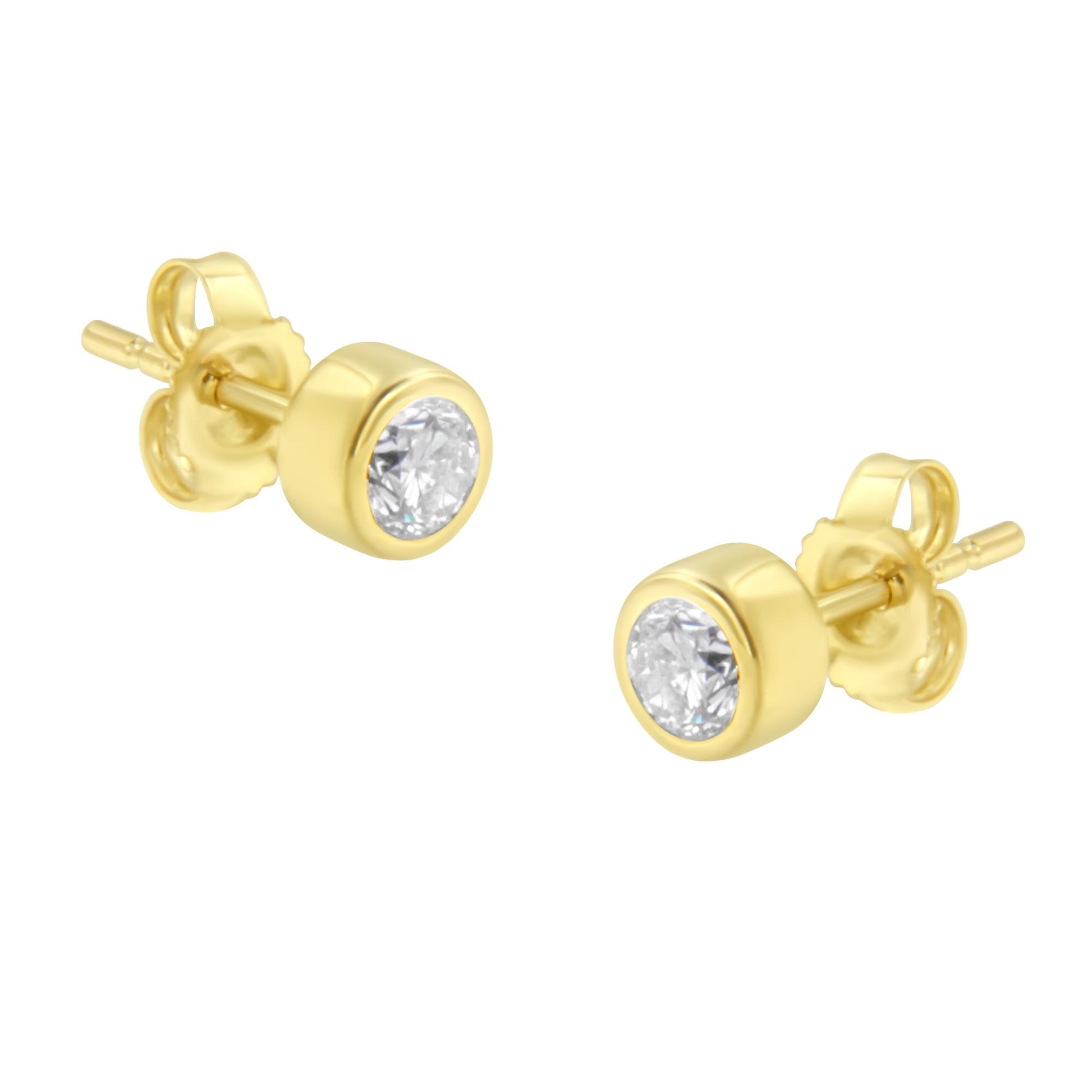 Pair of yellow metal stud earrings with round white gemstones in bezel setting, shown from a slightly elevated front angle.