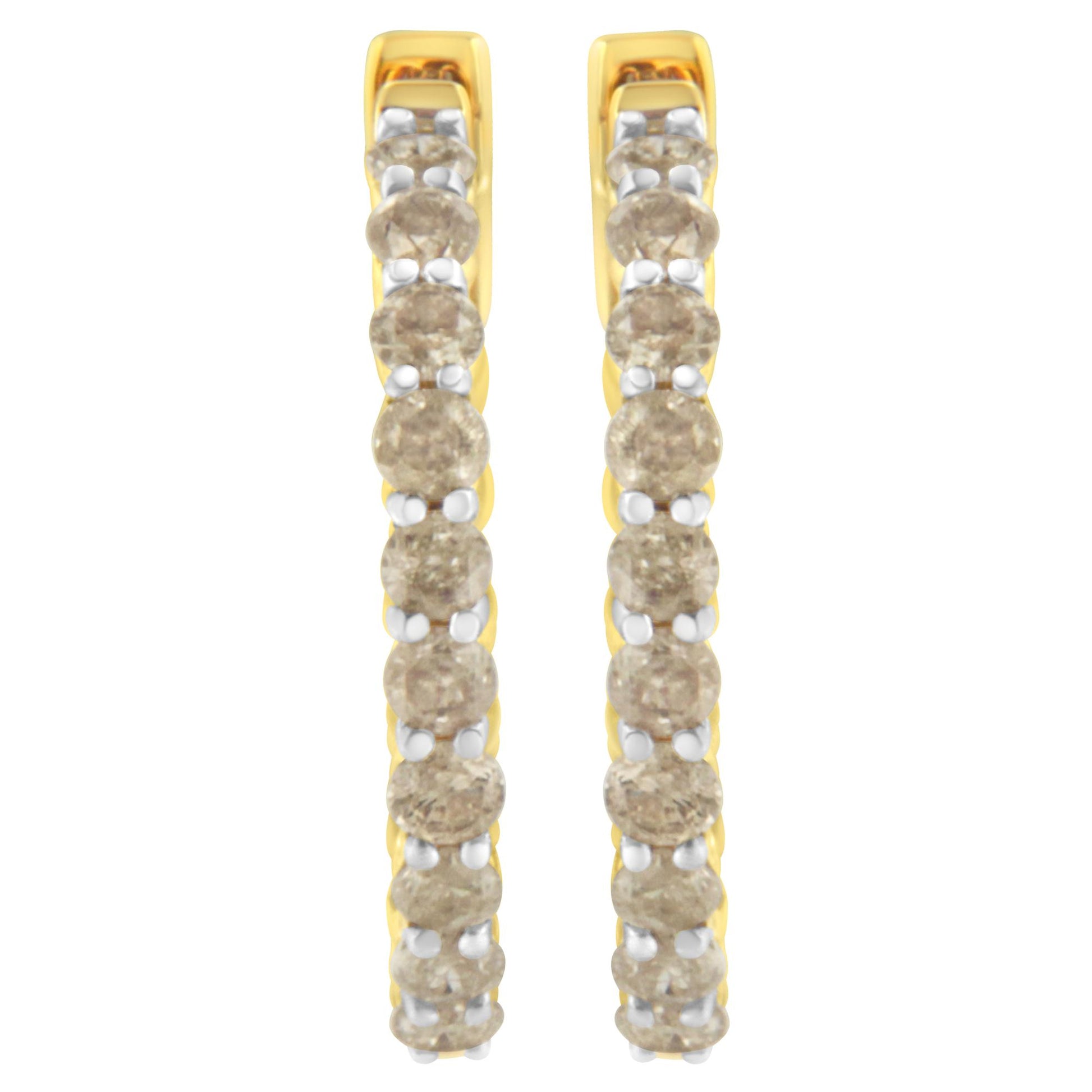 Front-facing close-up of a pair of yellow metal hoop earrings set with round prong-set brownish gemstones.
