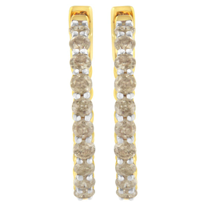 Front-facing close-up of a pair of yellow metal hoop earrings set with round prong-set brownish gemstones.