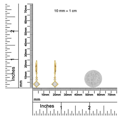 Pair of yellow and white metal drop earrings with square and round white gemstones, shown on a ruler and next to a coin for size reference, front-facing angle.