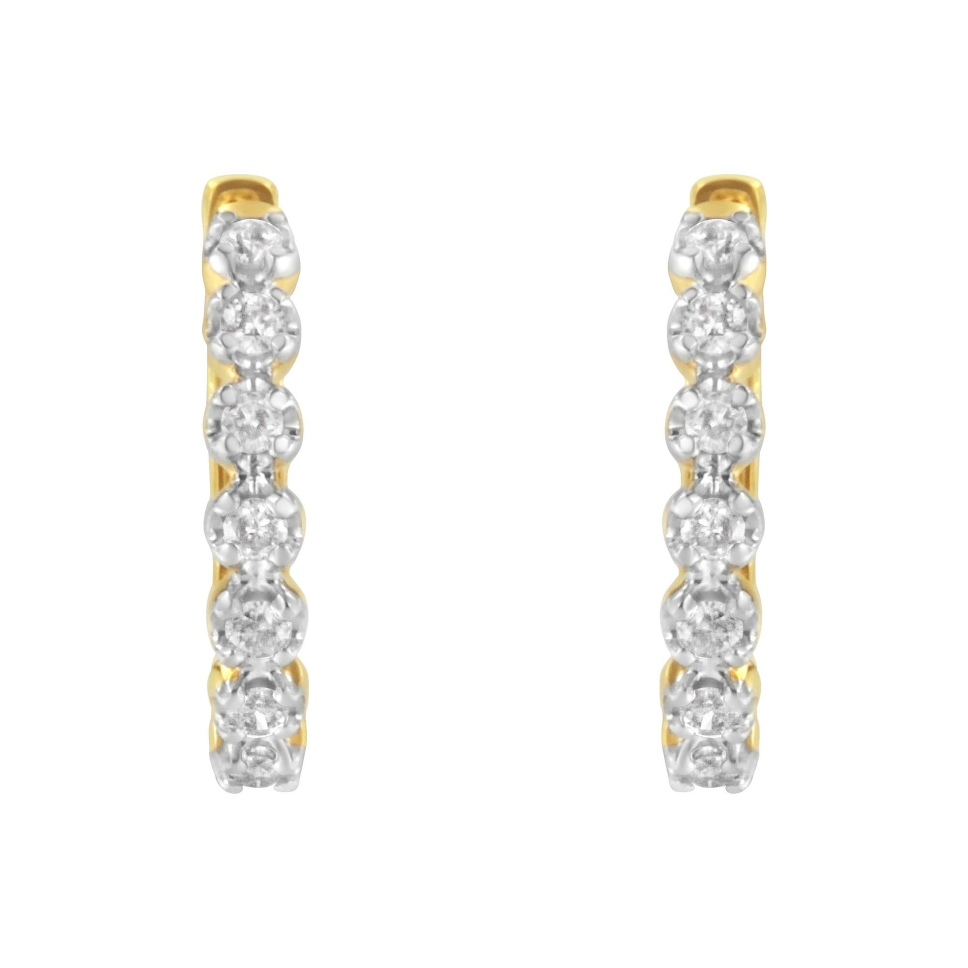 Front view of a pair of yellow metal hoop earrings with white round gemstones set in prong settings along the front.
