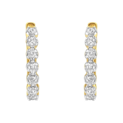 Front view of a pair of yellow metal hoop earrings with white round gemstones set in prong settings along the front.