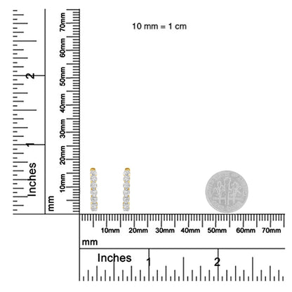 Pair of yellow metal earrings with vertical rows of prong-set round white gemstones, shown from the front on a ruler and next to a coin for size reference.