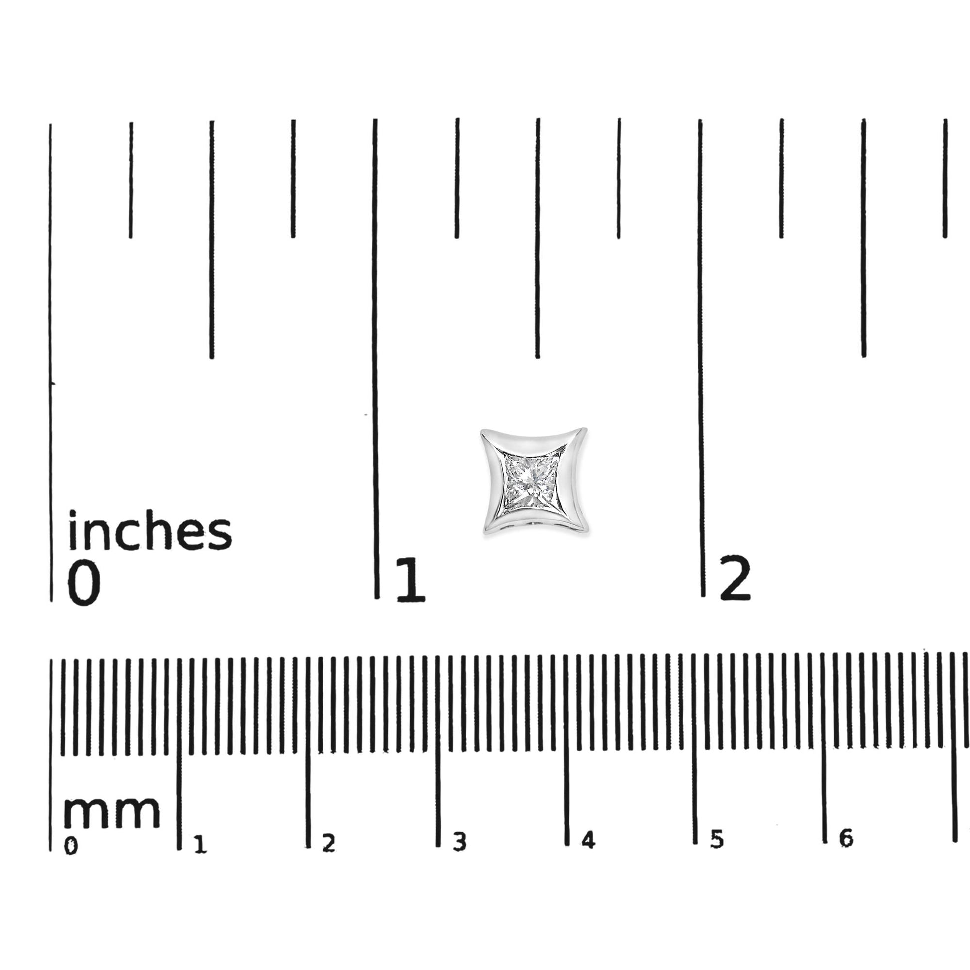 Close-up top view of a single white metal earring with a princess-shaped white gemstone in a channel setting, placed on a ruler for size reference.