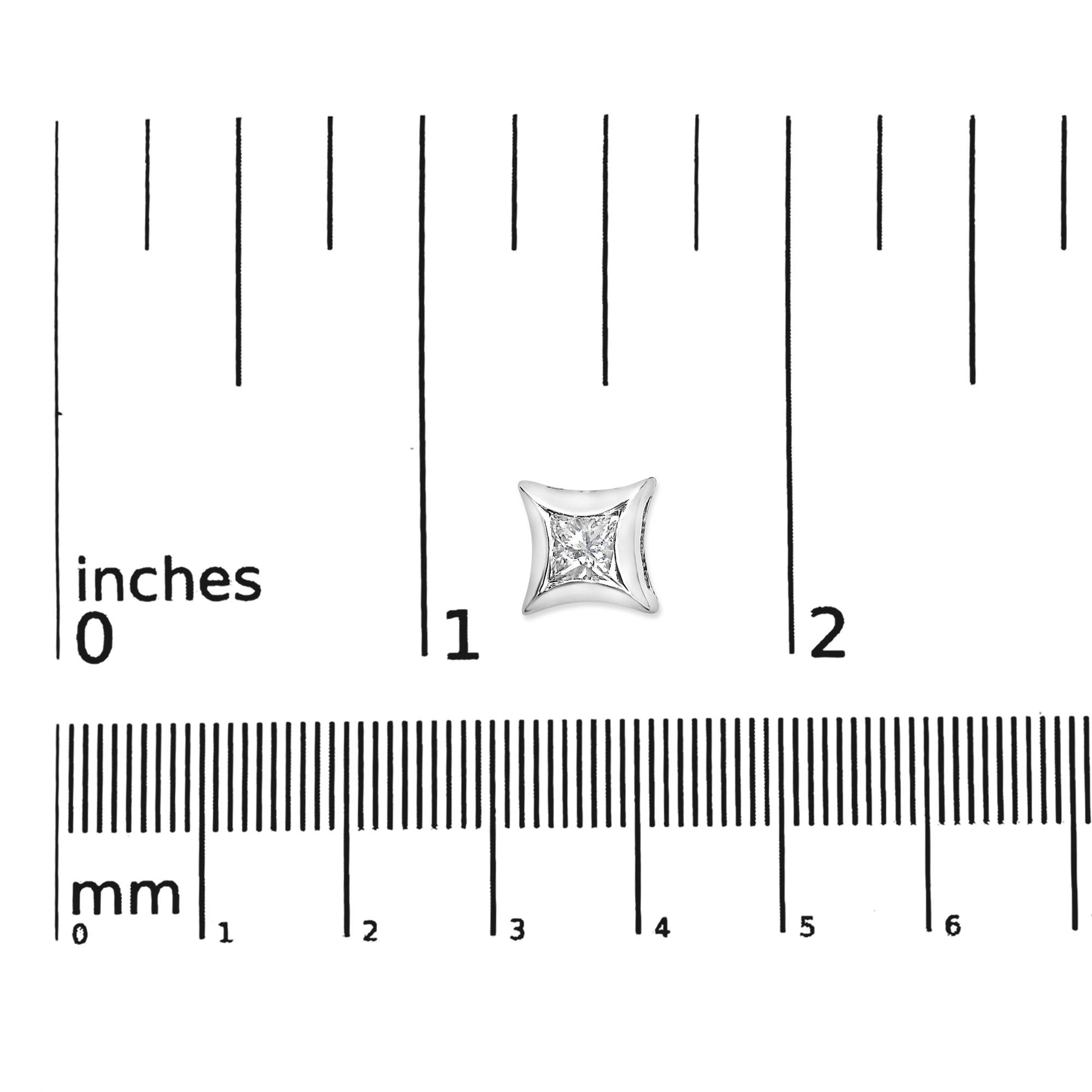 Close-up front view of a white earring with a princess-shaped white gemstone in an invisible setting on a ruler for size reference.