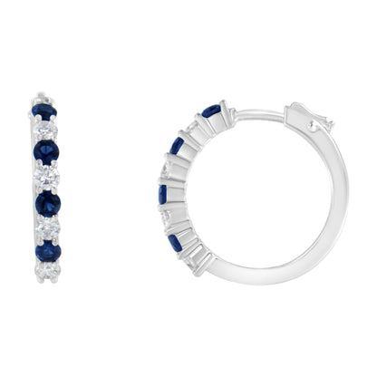 White metal hoop earrings with alternating blue and white round gemstones in prong settings, shown from front and side angles on a white background.