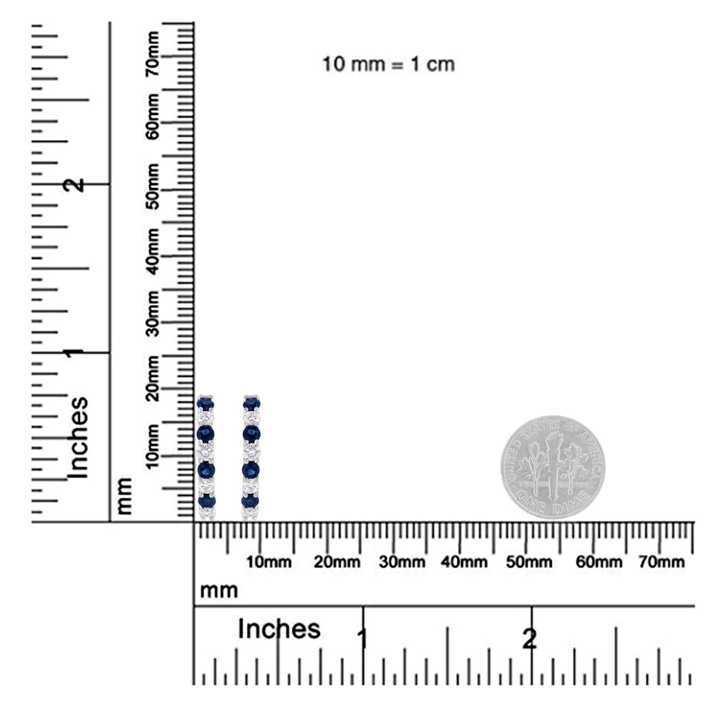 Pair of white metal earrings with alternating blue and white round gemstones in prong settings, shown upright on a ruler and scale for size reference with a coin beside them.