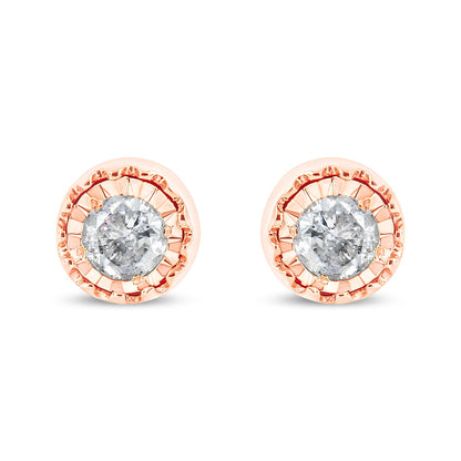 Front facing view of a pair of rose metal stud earrings each featuring a round white gemstone in a miracle setting.