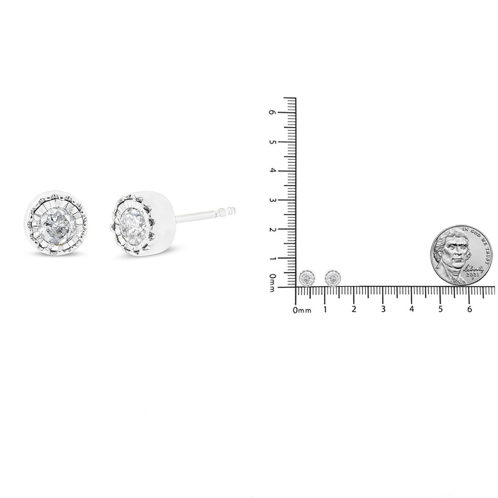 Close-up front and side view of white metal round stud earrings with white gemstones in miracle setting, shown next to a ruler and coin for size reference.