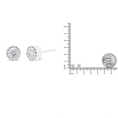 Close-up front and side view of white metal round stud earrings with white gemstones in miracle setting, shown next to a ruler and coin for size reference.