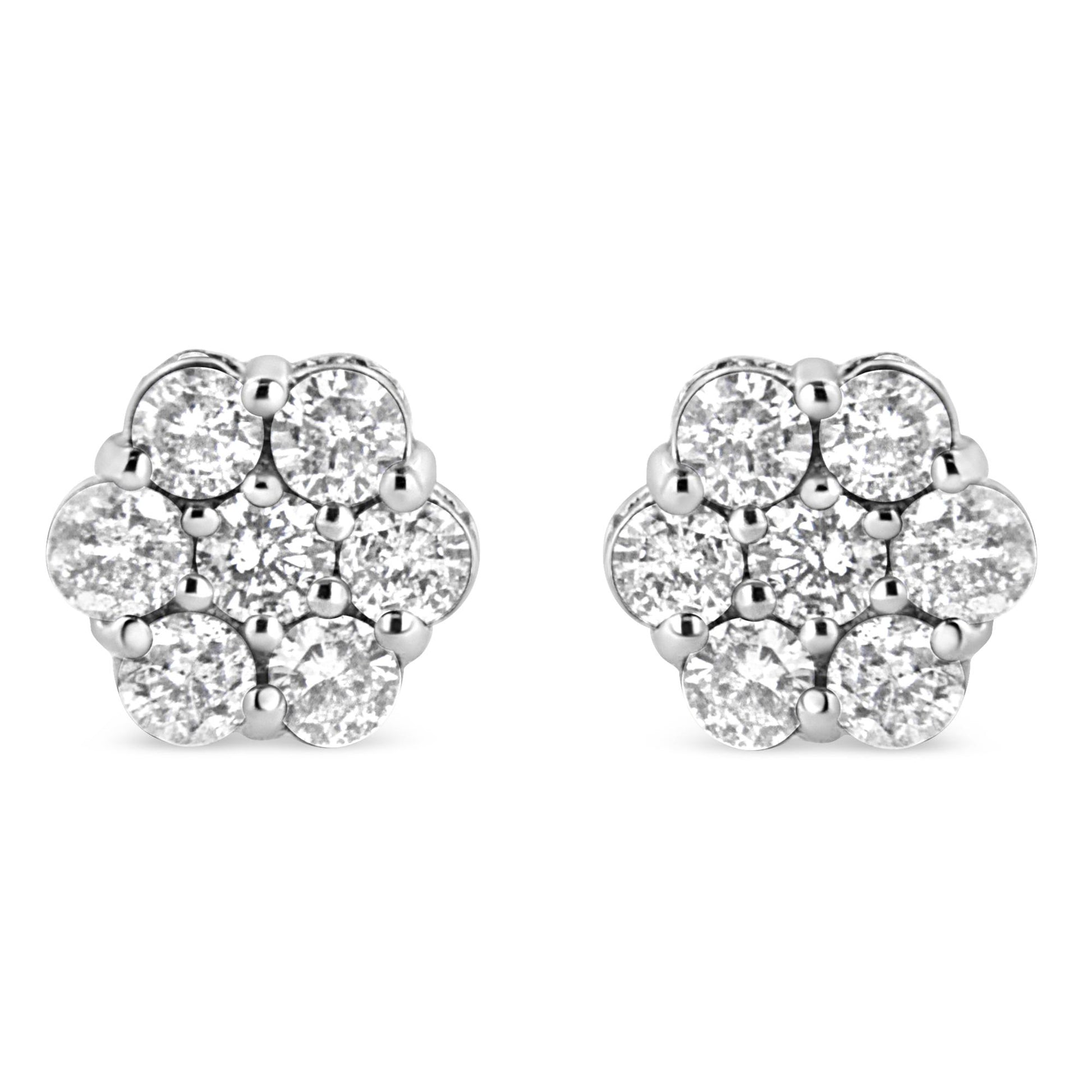 Front view of a pair of white metal floral-shaped stud earrings featuring round white gemstones in prong and channel settings.