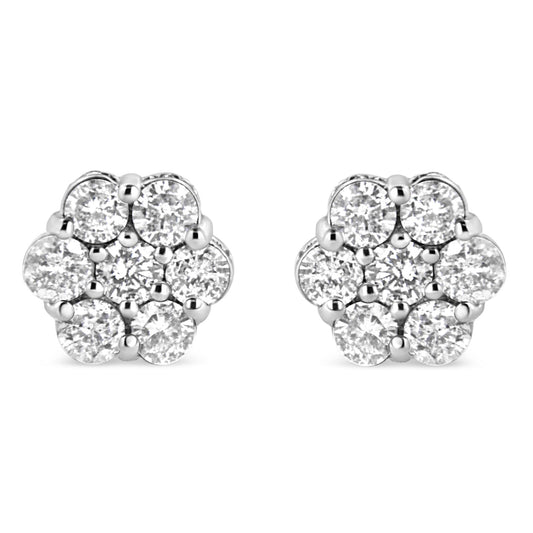 Front view of a pair of white metal floral-shaped stud earrings featuring round white gemstones in prong and channel settings.