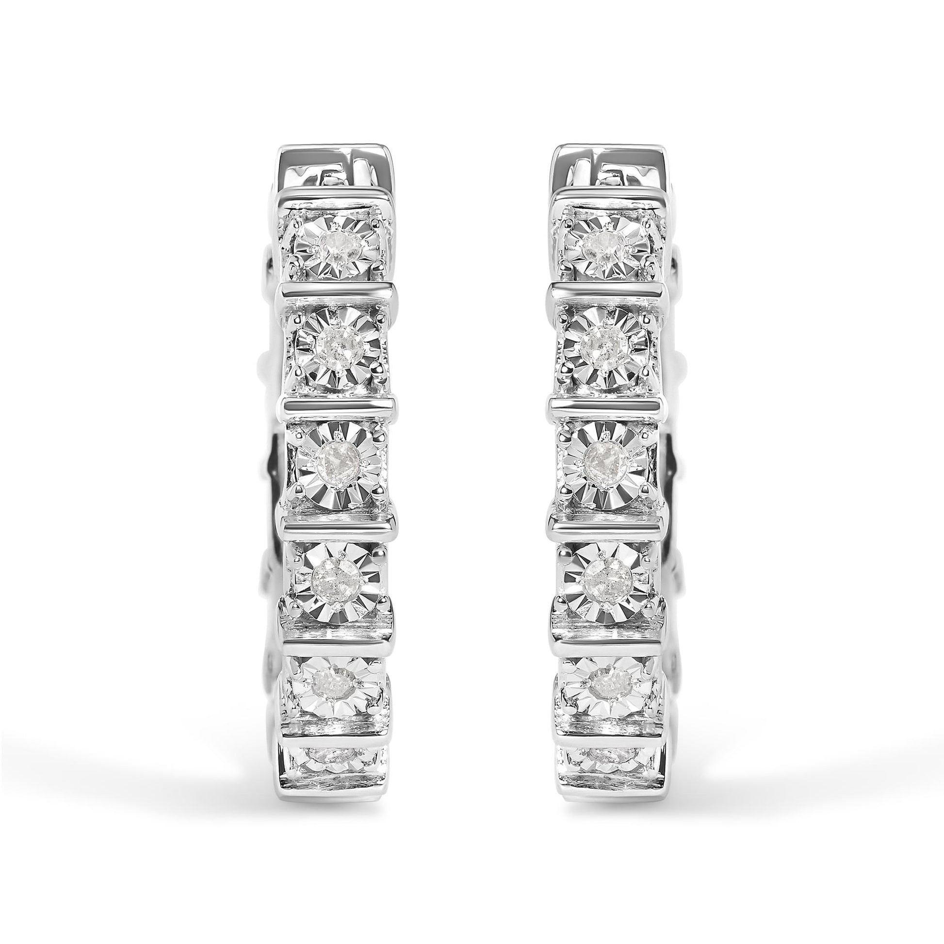 Front view of a pair of white metal hoop earrings set with multiple round white gemstones in a miracle setting.