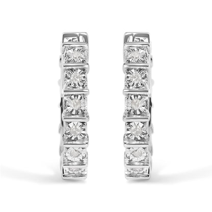 Front view of a pair of white metal hoop earrings set with multiple round white gemstones in a miracle setting.