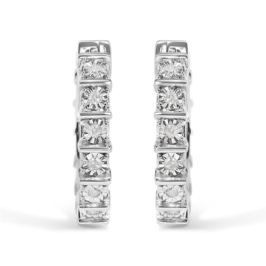 Front view of a pair of white metal hoop earrings set with multiple round white gemstones in a miracle setting.