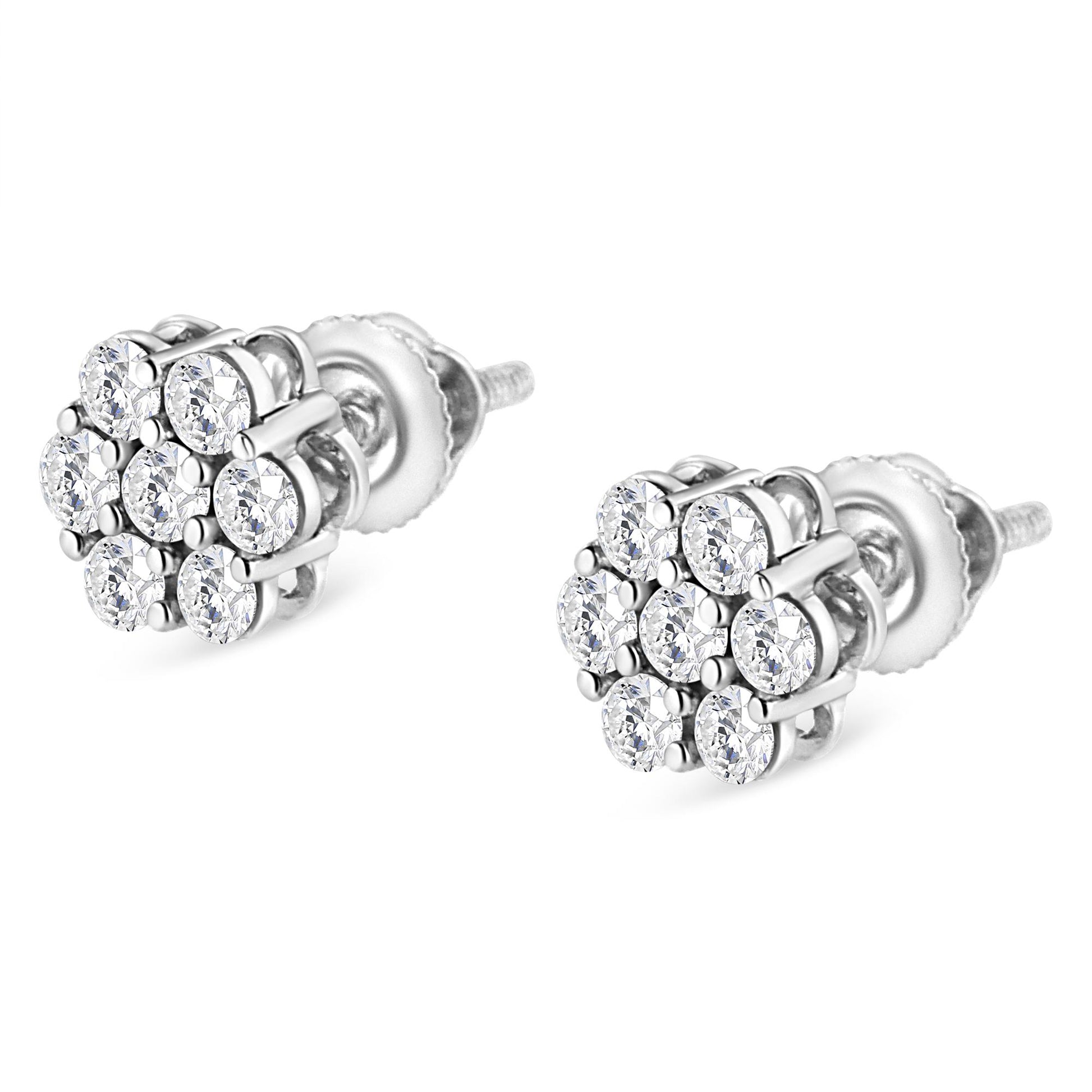 Pair of white metal stud earrings with round white gemstones in prong settings, shown at a slight angle.