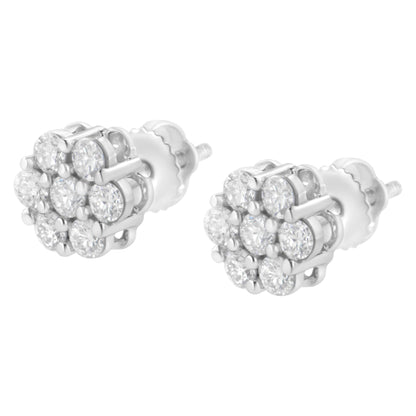 Pair of white metal stud earrings with cluster of round white gemstones in prong settings, shown in close-up angled view.