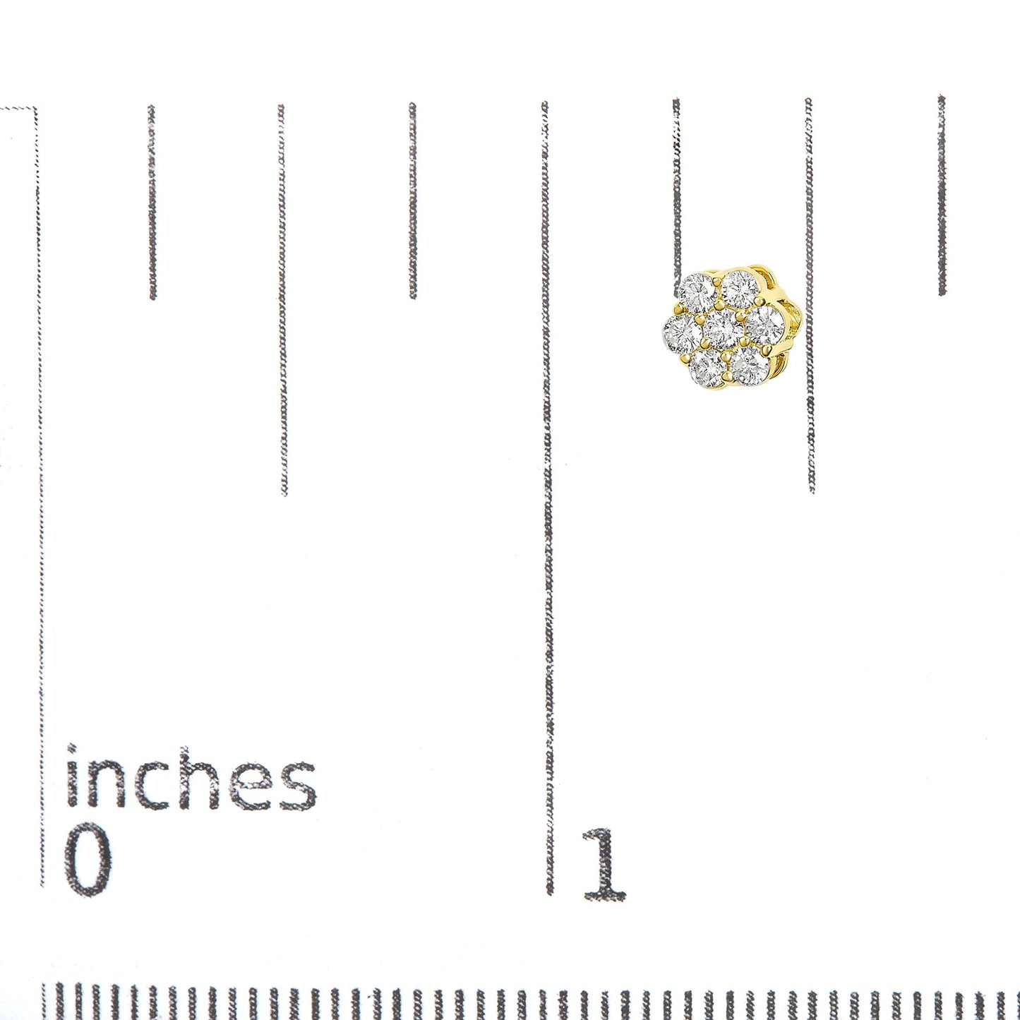 Close-up front angle of a yellow metal earring with round white gemstones in prong settings, placed on a ruler for size reference.