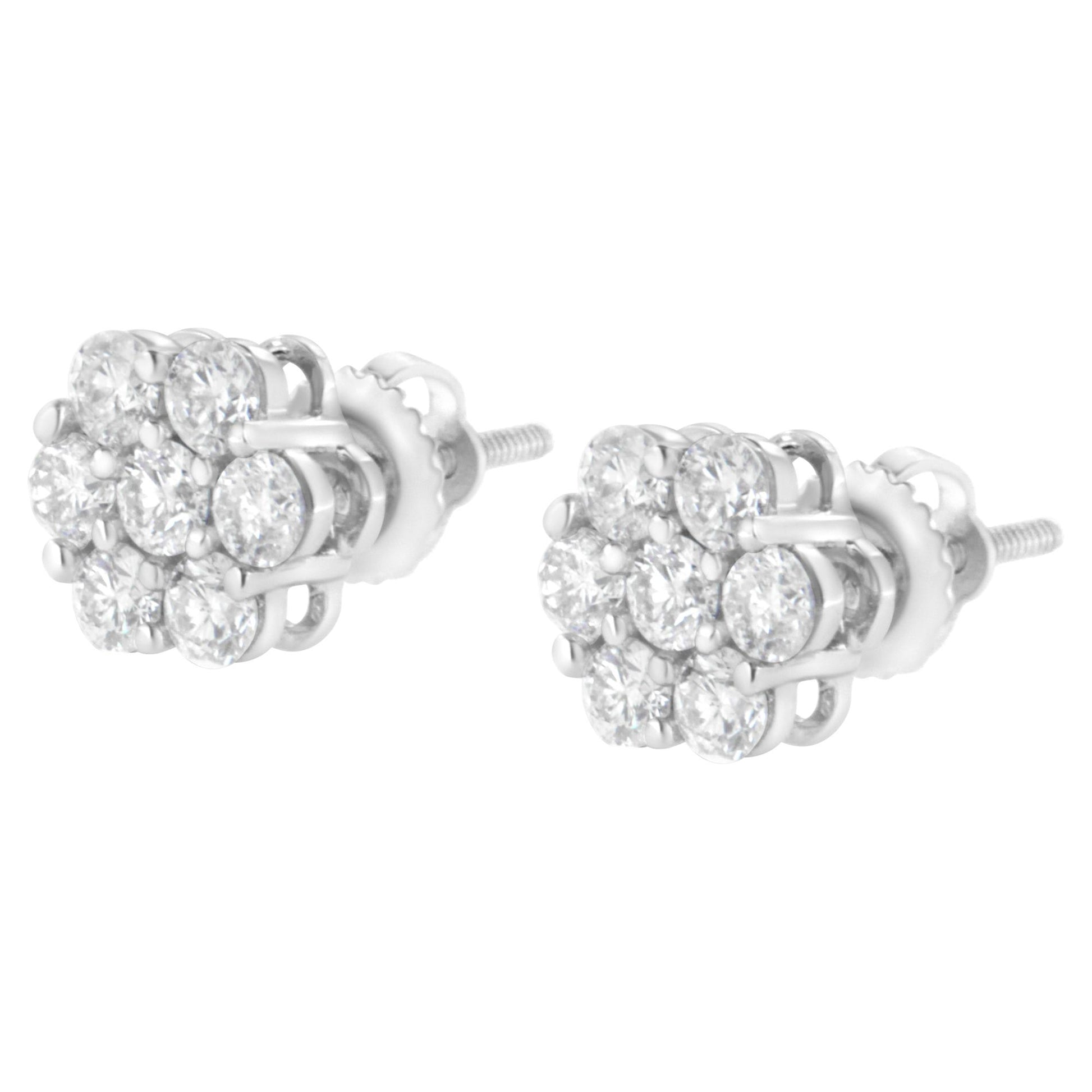 Pair of white metal stud earrings with clusters of round white gemstones in prong settings, shown at a slight angle.