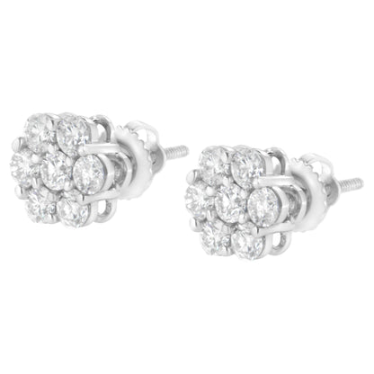 Pair of white metal stud earrings with clusters of round white gemstones in prong settings, shown at a slight angle.