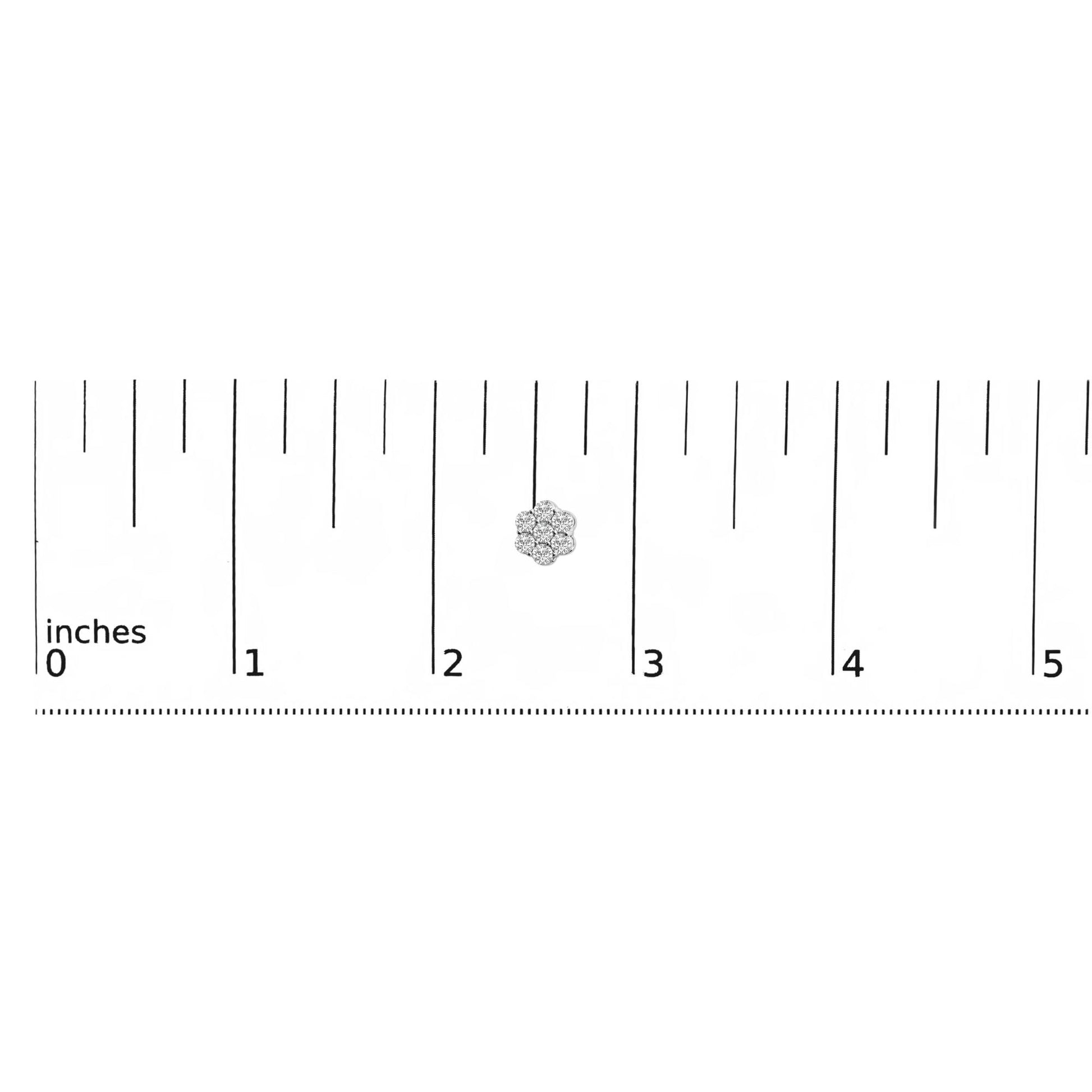 Close-up front view of a white metal earring with round white gemstones in prong settings arranged in a floral cluster, displayed on a ruler for size reference.