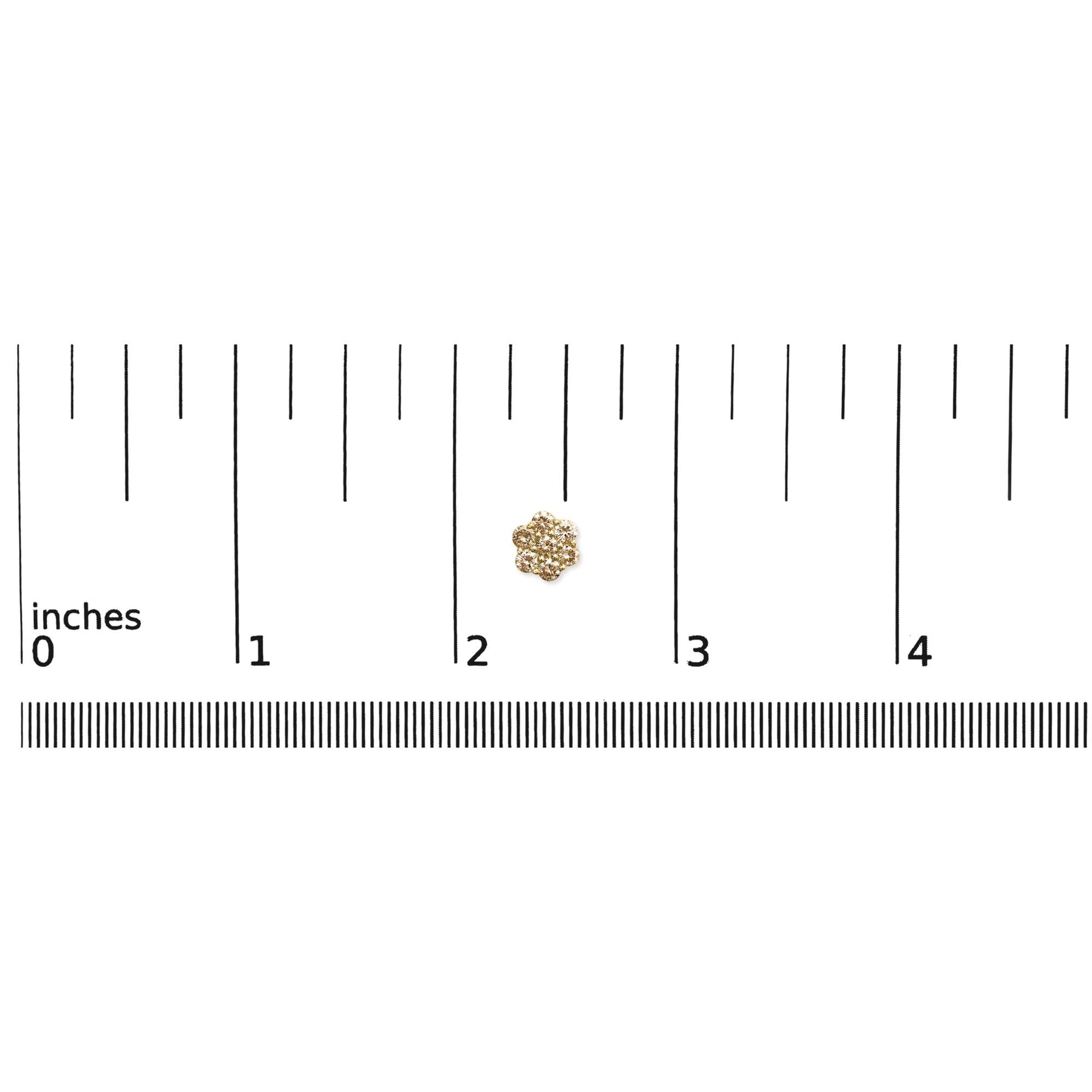 Close-up front view of yellow metal earrings with clustered round white gemstones, placed on a ruler for size reference.