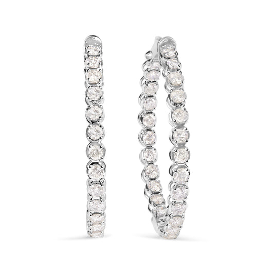 Pair of white metal hoop earrings set with round white gemstones in prong settings, shown from a front angle.