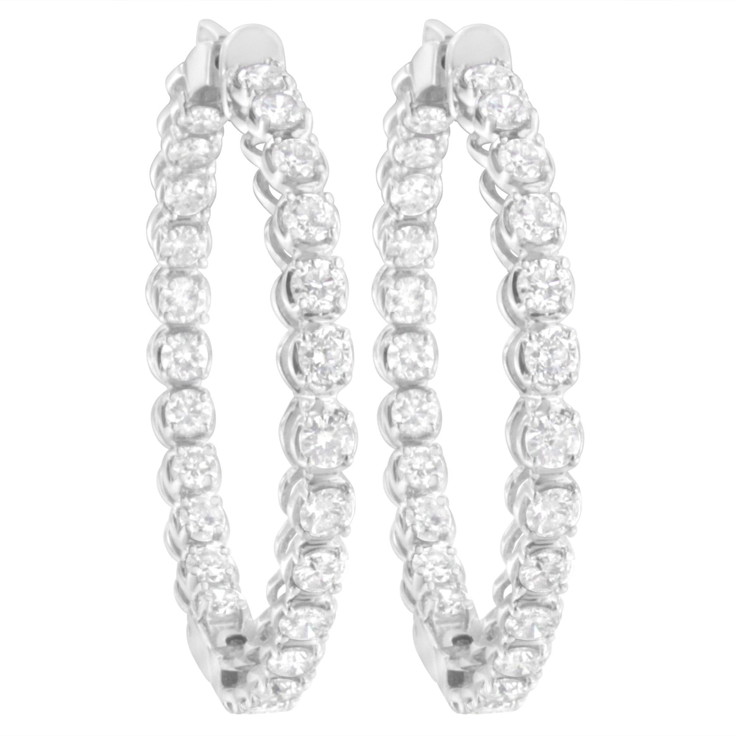 Pair of white metal hoop earrings with round white gemstones in prong settings, shown from a front angle.