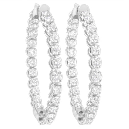 Pair of white metal hoop earrings with round white gemstones in prong settings, shown from a front angle.
