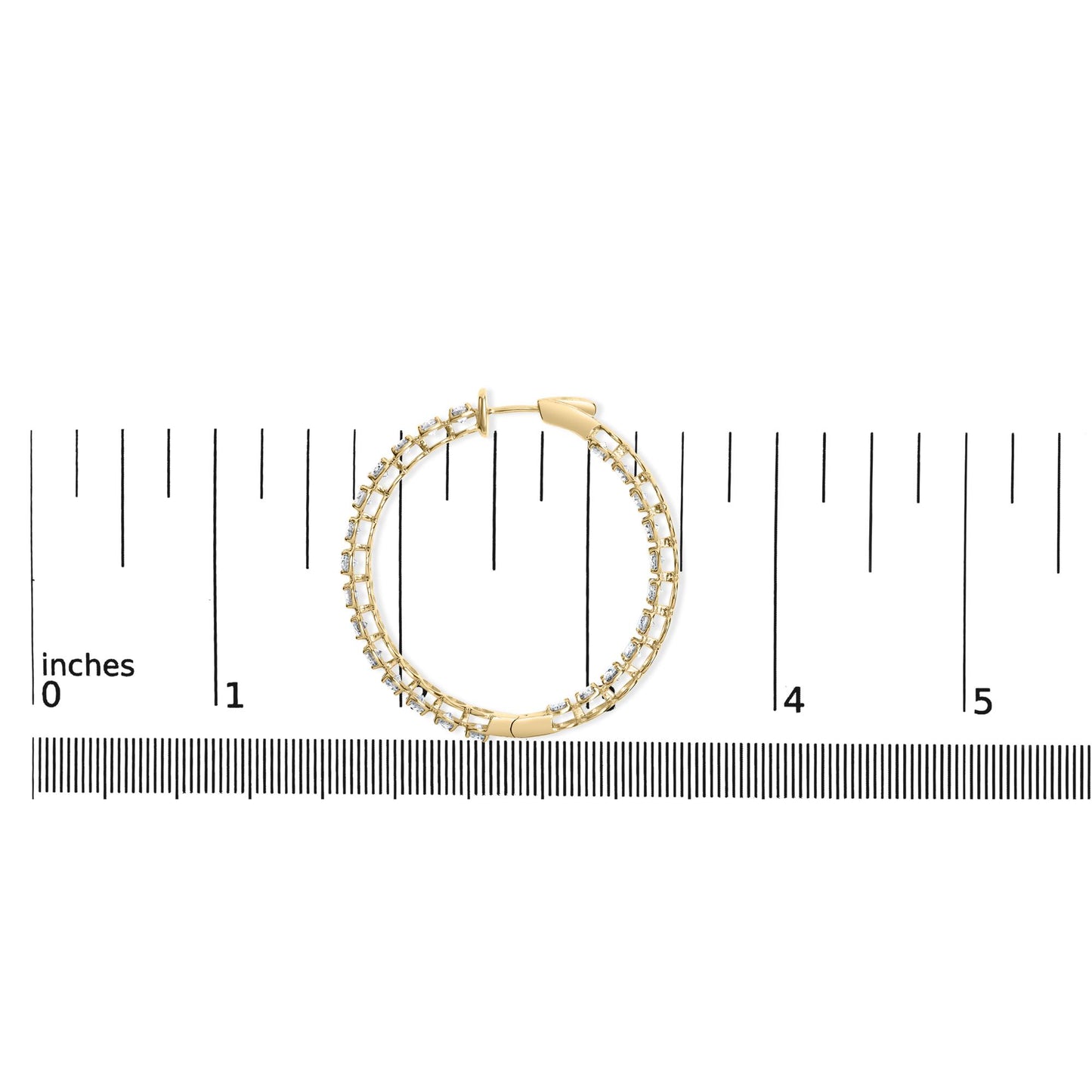Yellow metal hoop earring with round white gemstones in prong setting, shown flat on a ruler for scale, top-down view.