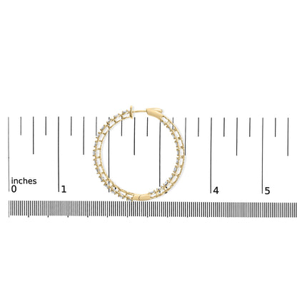 Yellow metal hoop earring with round white gemstones in prong setting, shown flat on a ruler for scale, top-down view.