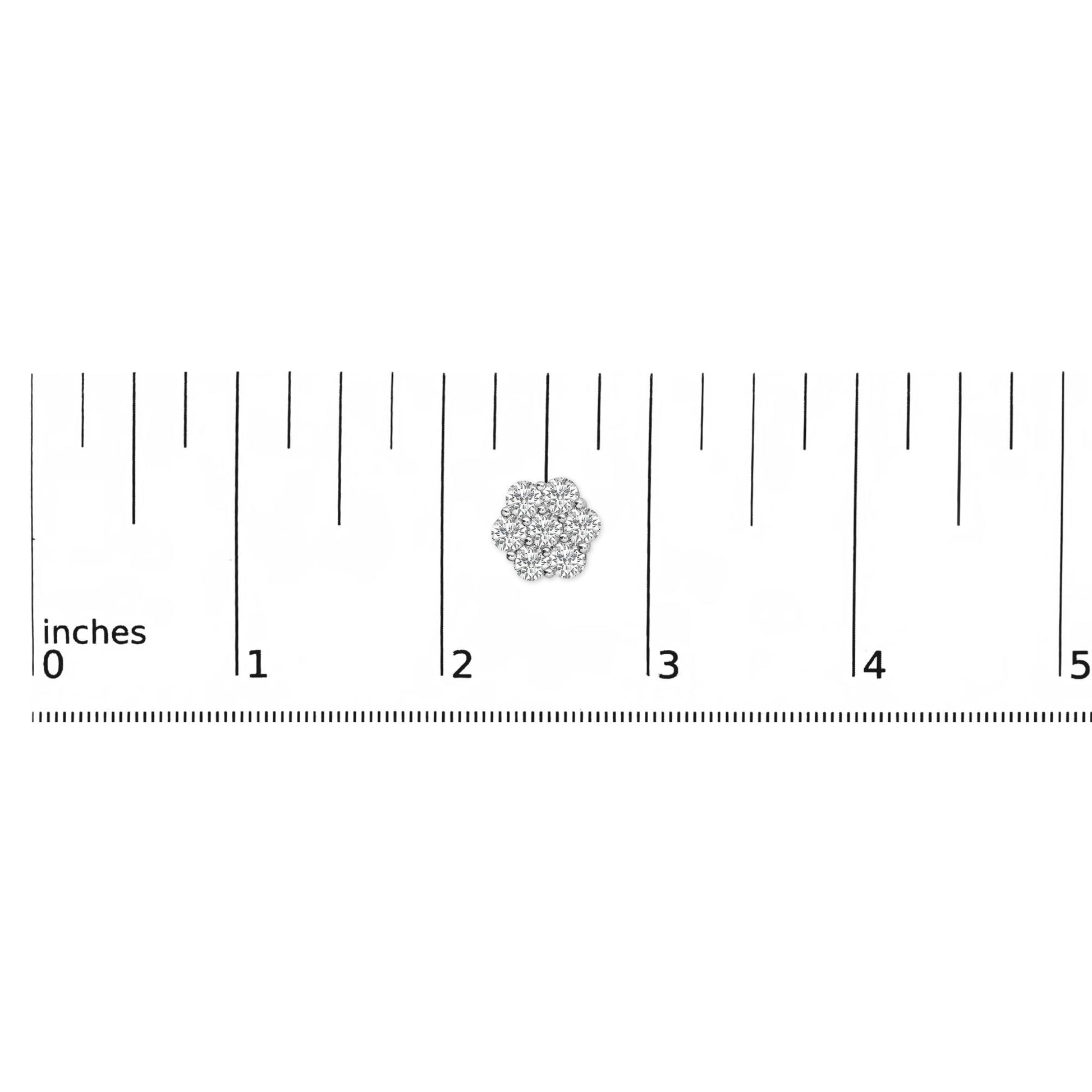 Close-up overhead shot of a white earring with multiple round white gemstones in a shared prong setting, positioned on a ruler for size reference.