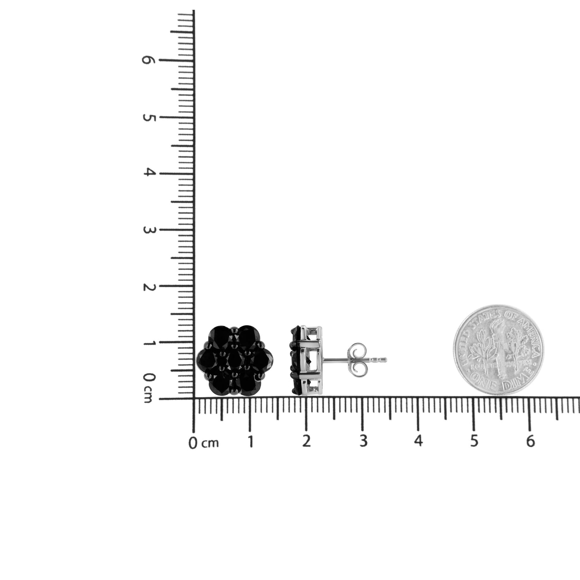Pair of white metal stud earrings with clustered round black gemstones in prong settings, shown from front and side angles on a ruler for size reference.