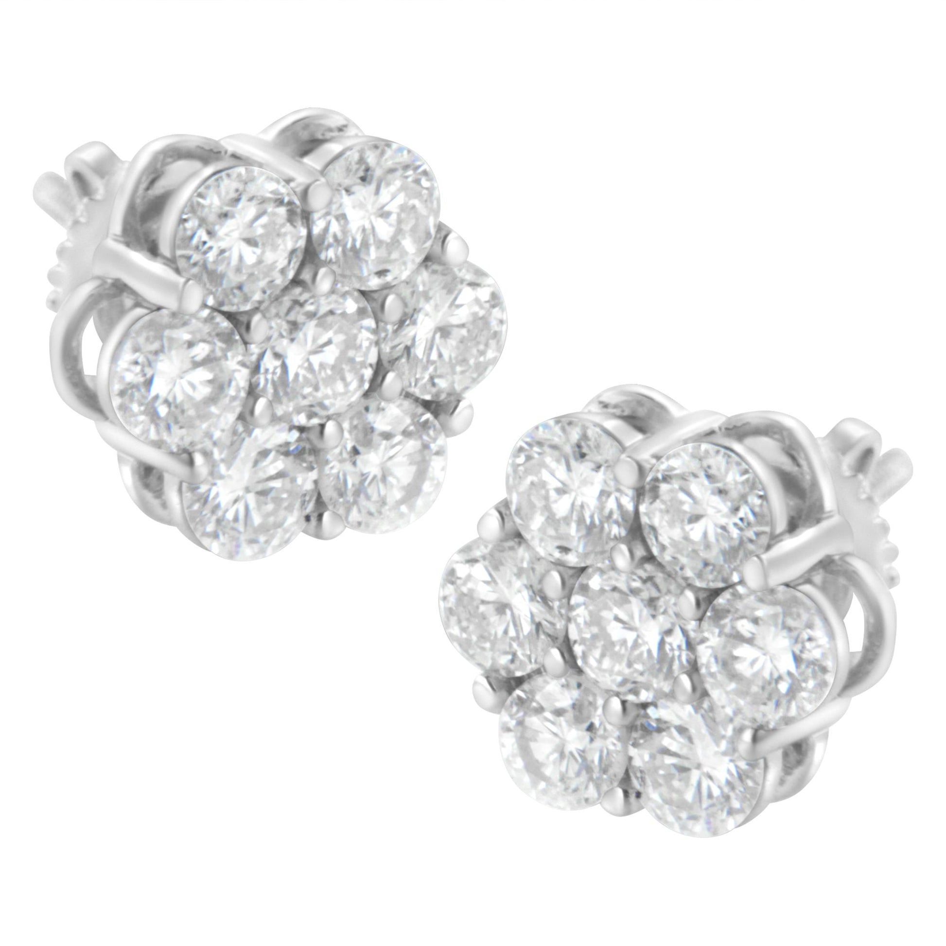 Pair of white metal stud earrings with round white gemstones in prong settings arranged in a cluster, shown from a front angle.
