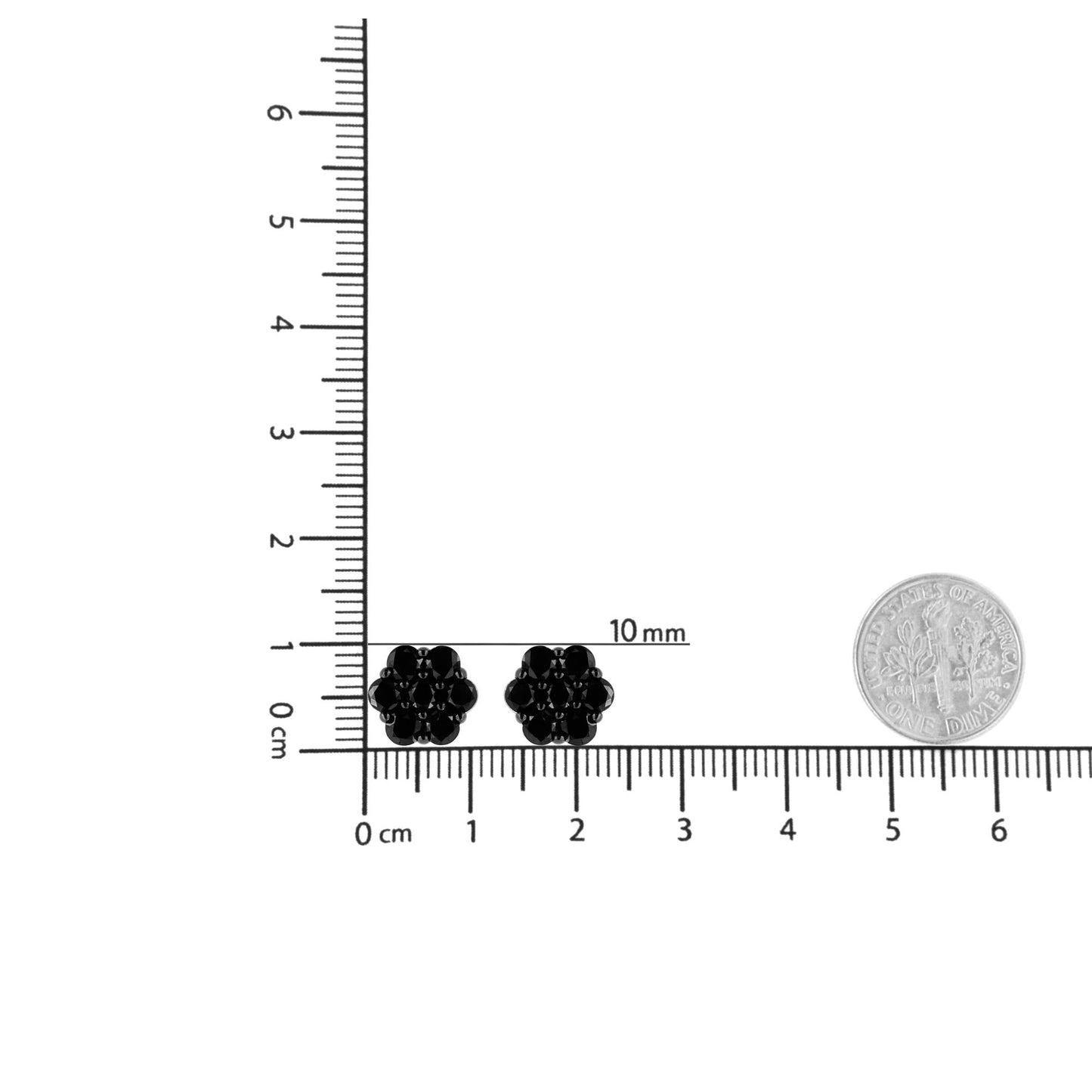 Top-down view of white metal earrings with round black gemstones in a cluster design, placed next to measuring scales and a coin for size reference.