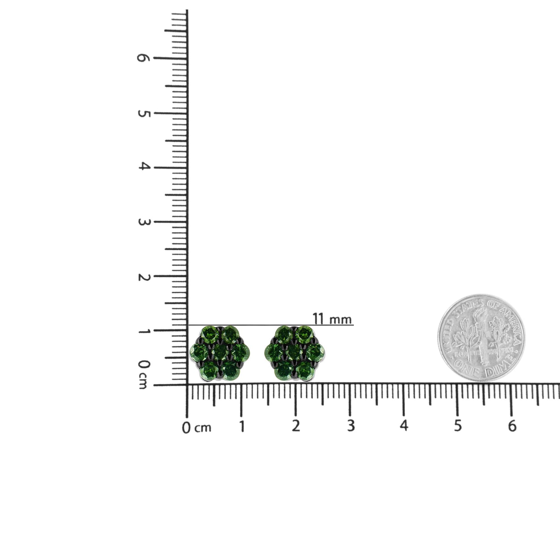 Pair of white metal stud earrings with round prong-set green gemstones arranged in a cluster design, displayed on a ruler and shown from a top-down angle.