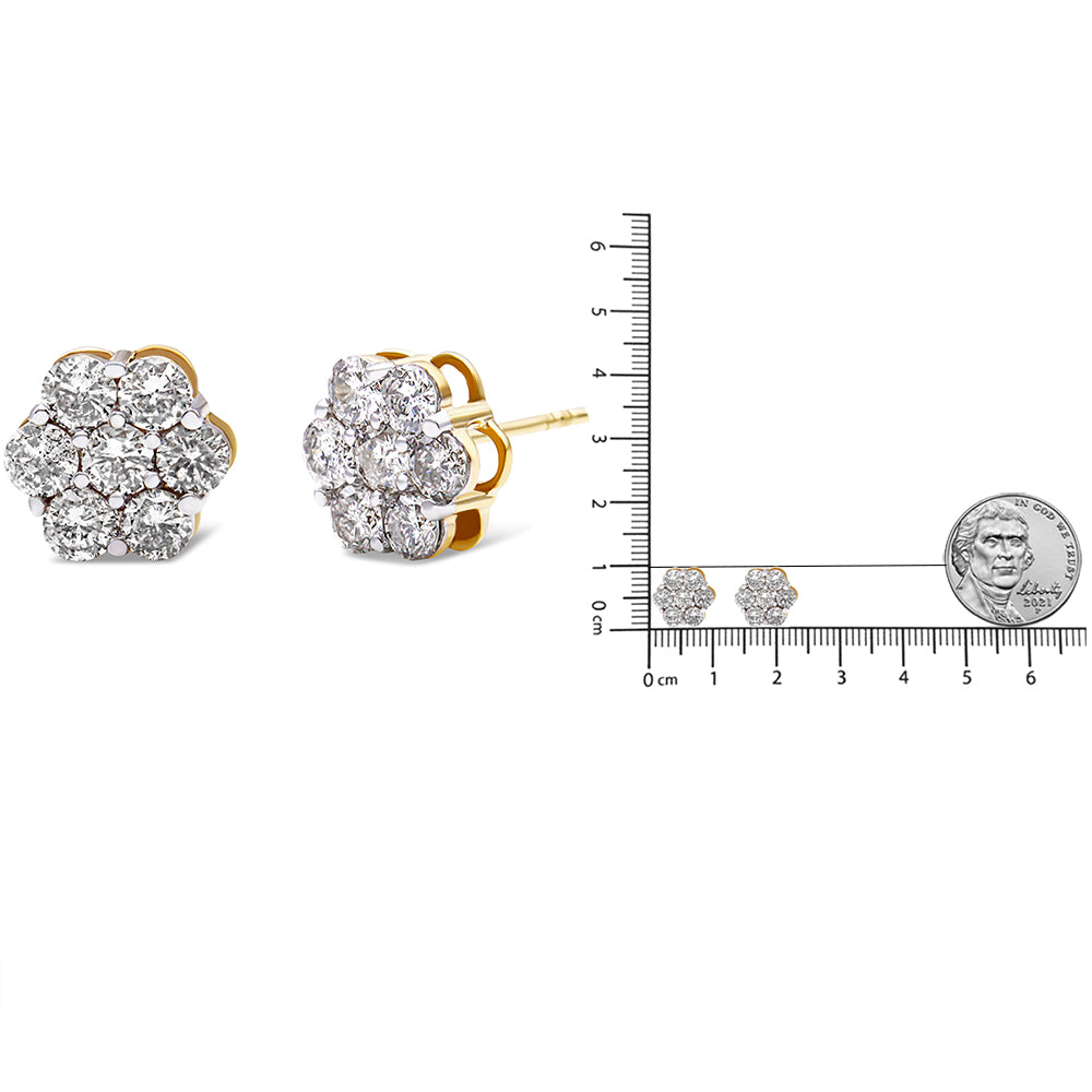 Pair of yellow metal flower-shaped stud earrings with round white gemstones in prong settings, shown from front and side angles next to a ruler and coin for size reference.