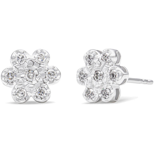 Front and side angled view of white metal flower-shaped stud earrings with round white gemstones in prong settings.