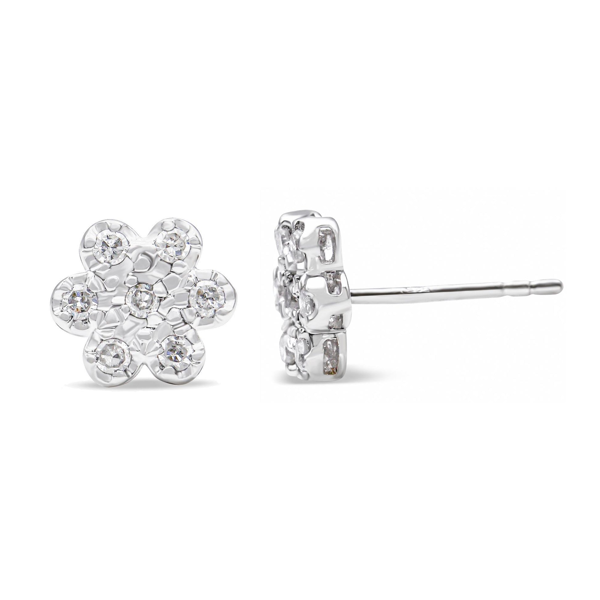 Pair of white metal flower-shaped stud earrings with round white gemstones in prong settings, shown from front and side angles.