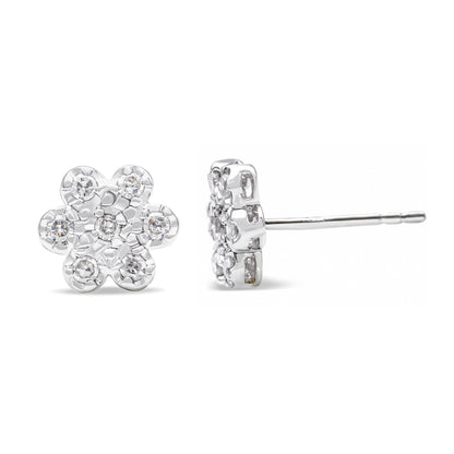 Pair of white metal flower-shaped stud earrings with round white gemstones in prong settings, shown from front and side angles.