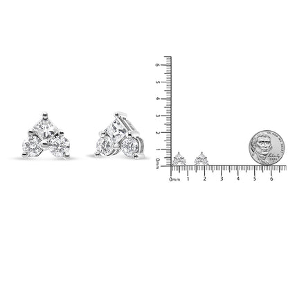 Pair of white metal earrings with triangular design featuring a princess-shaped white gemstone and round white gemstones, shown from front and side angles next to a ruler and coin for size reference.