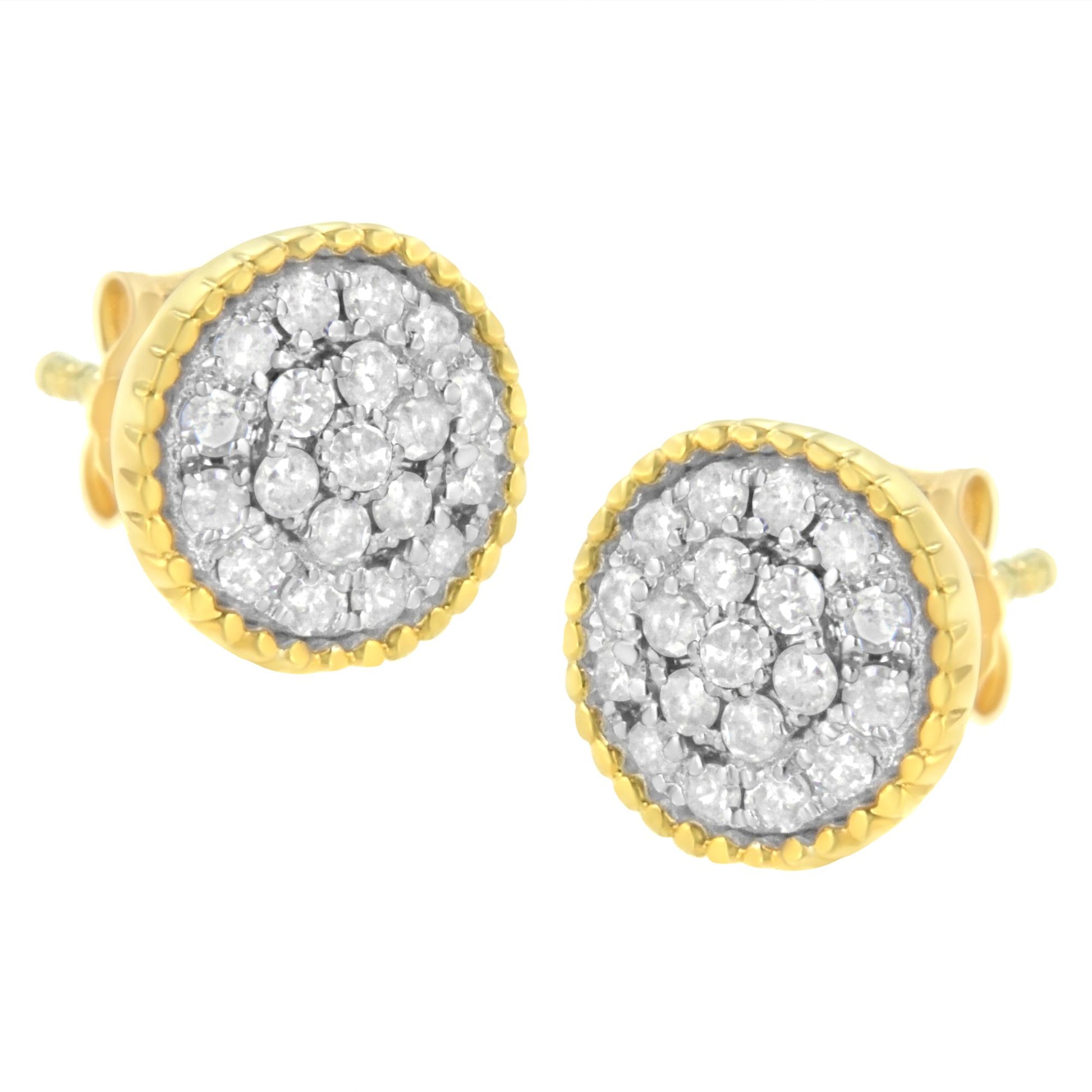 Close-up front angle of a pair of round earrings with white gemstones in prong settings, surrounded by yellow metal edges.